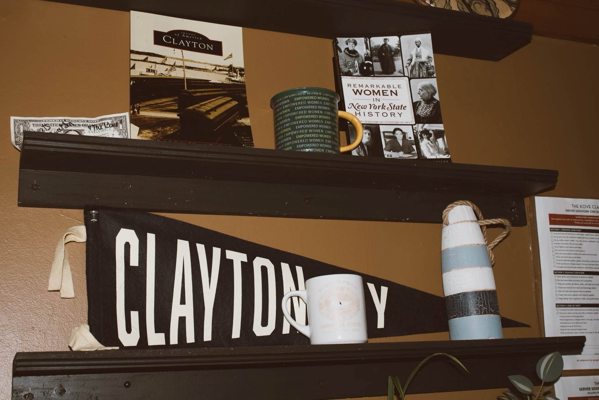 Clayton pennant flag and local history books on shelves at The Kove